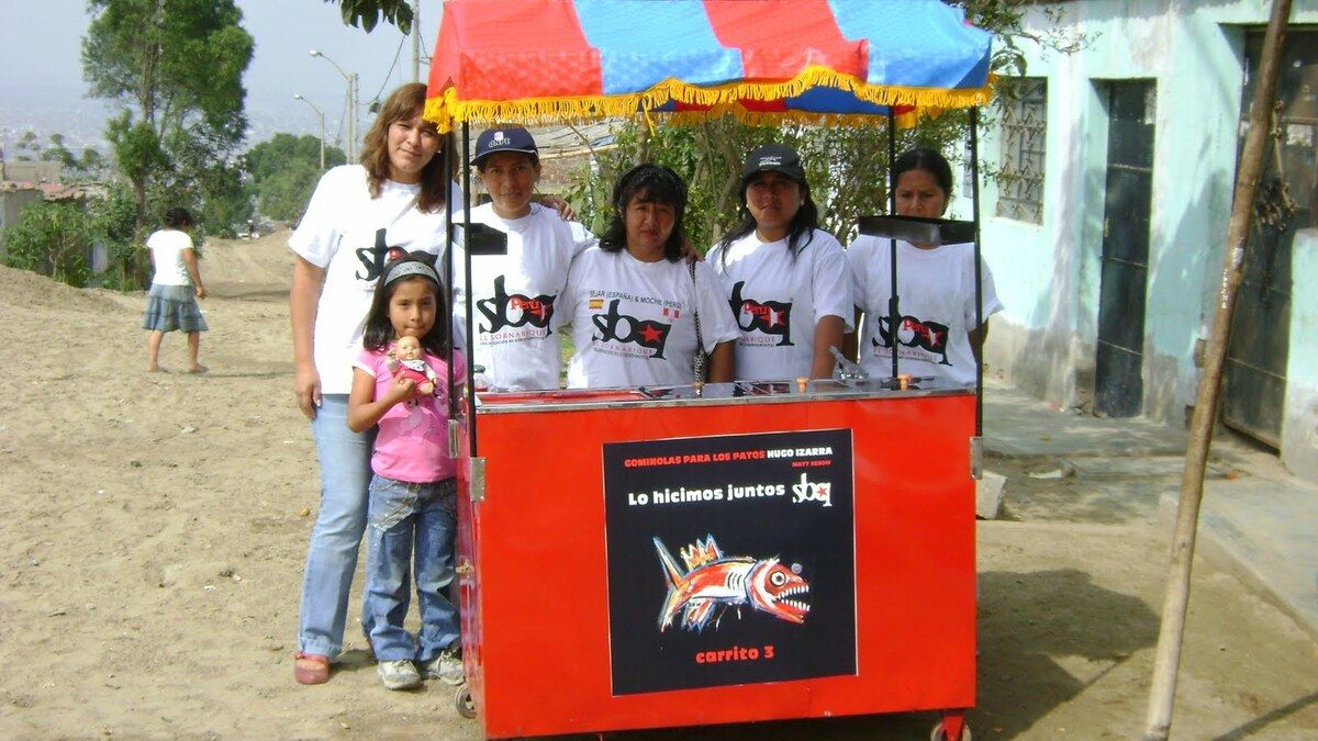 Book — Hugo Izarra, “Gominolas para los patos” (Candy for the Ducks), illustrated by Matt Sesow (Béjar: SBQ, 2011), 2011: photograph 3 (The food cart with Matt’s fish painting, Cerro Cabras (Alto Trujillo), Peru, July 3, 2011)
