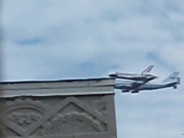 The shuttle passing a carved cornice seen from the studio.